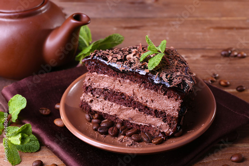 Delicious chocolate cake with mint on plate on table close up
