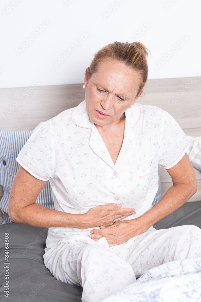 Seniorin im Bett mit Bauchschmerzen Seniorin im Bett mit Bauchschmerzen