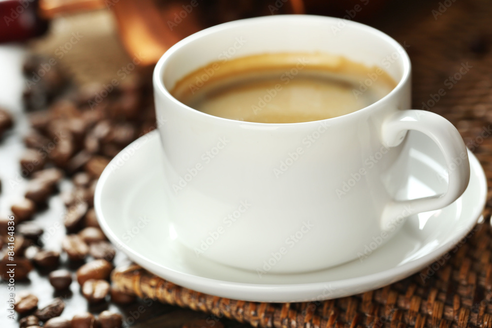 Cup of coffee with beans on table close up Cup of coffee with beans on table close up
