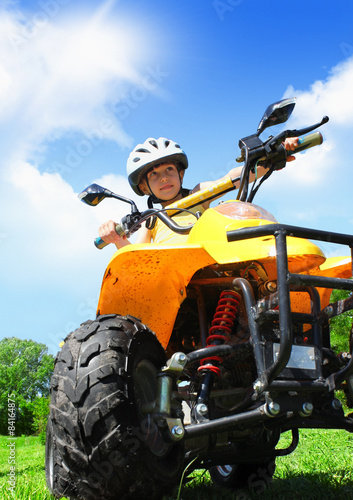 Child girl rides on quad photo