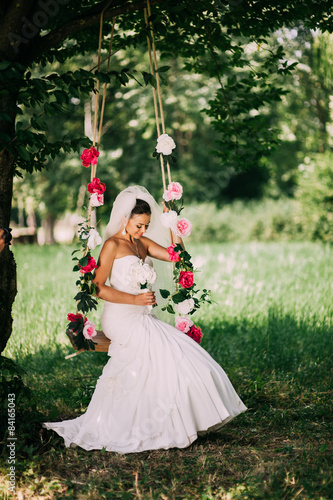 Beautiful bride swinging on a swing