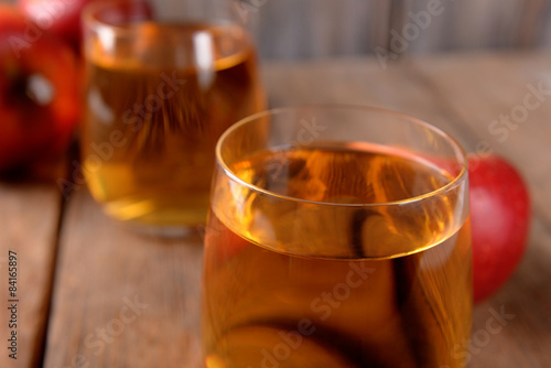 Fototapeta Naklejka Na Ścianę i Meble -  Glasses of apple juice on wooden table, closeup