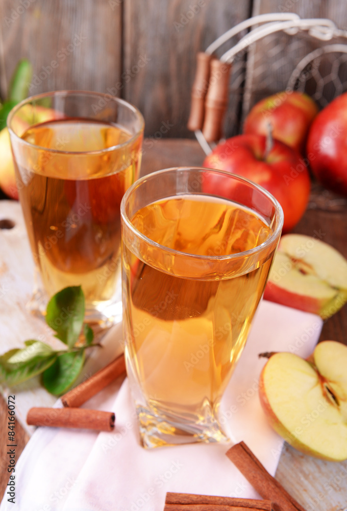Glasses of apple juice on wooden table, closeup Glasses of apple juice on wooden table, closeup