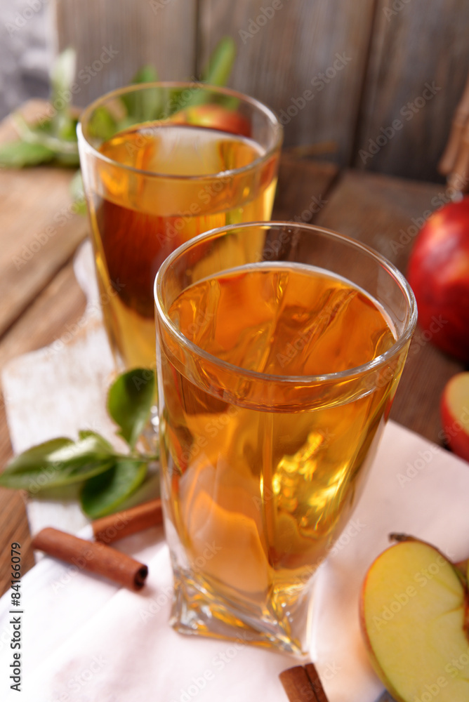 Glasses of apple juice on wooden table, closeup Glasses of apple juice on wooden table, closeup