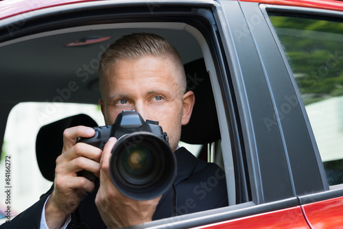 Man Photographing With Slr Camera From Car