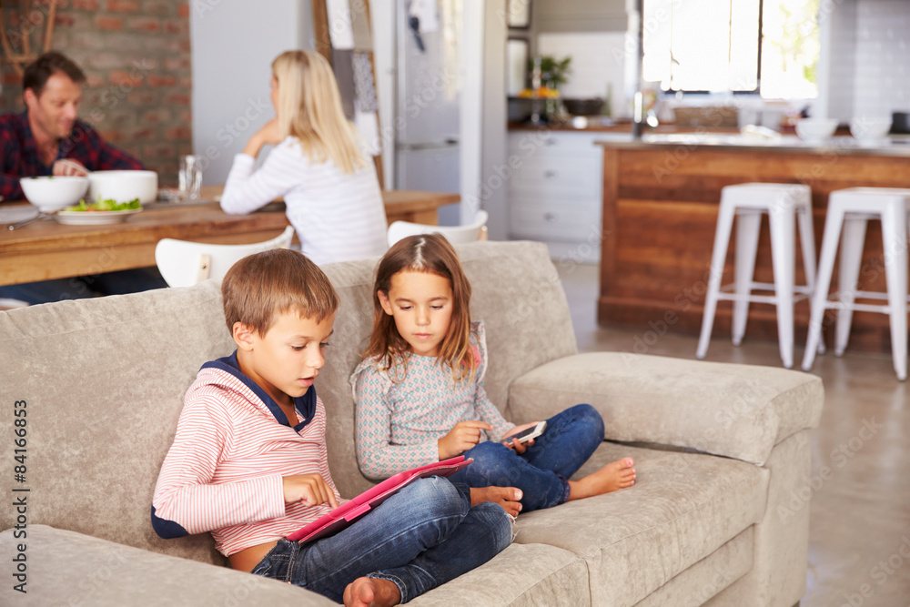 Kids playing with new technology while adults entertain Kids playing with new technology while adults entertain
