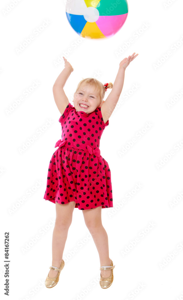 Joyful little girl jumps high for an inflatable ball Joyful little girl jumps high for an inflatable ball
