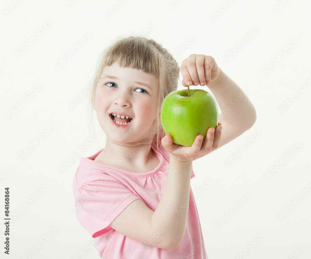 Happy little girl showing a green apple Happy little girl showing a green apple