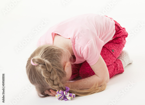 Sorrowful little girl on the floor
