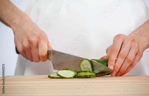 Cook cutting fresh cucumber