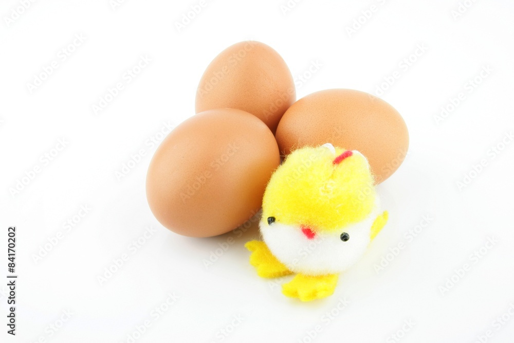 Little yellow stuffed easter chick on top of three eggs, on a white background. Little yellow stuffed easter chick on top of three eggs, on a white background.