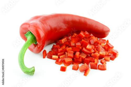 A single red sweet pointy pepper(capsicum) with a diced one in front of it