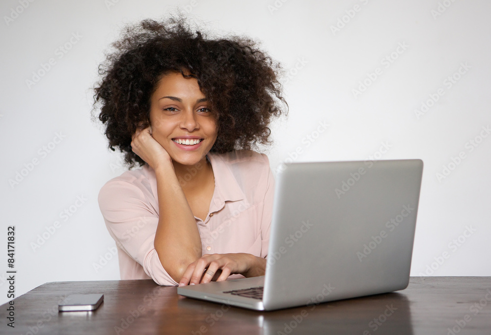 Smiling young woman sitting at table with laptop Smiling young woman sitting at table with laptop