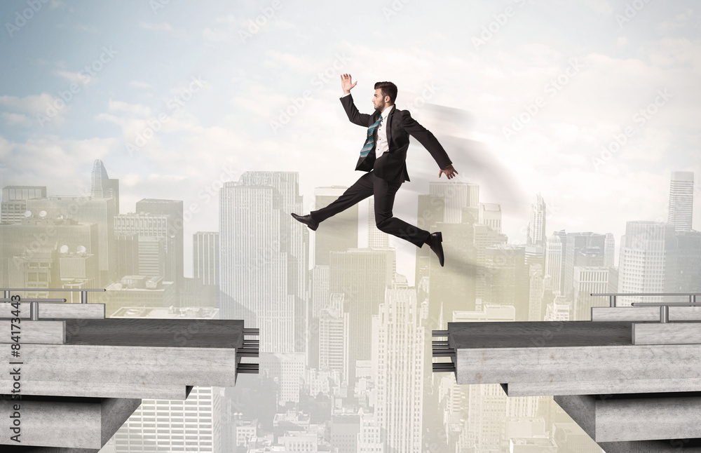 Energetic business man jumping over a bridge with gap Energetic business man jumping over a bridge with gap