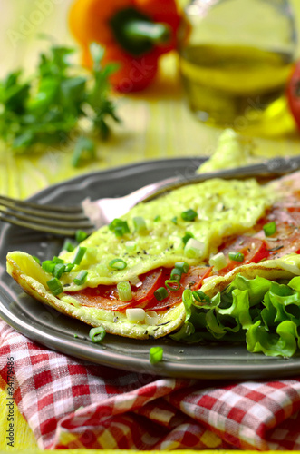 Omelet stuffed with tomatoes and cheese.