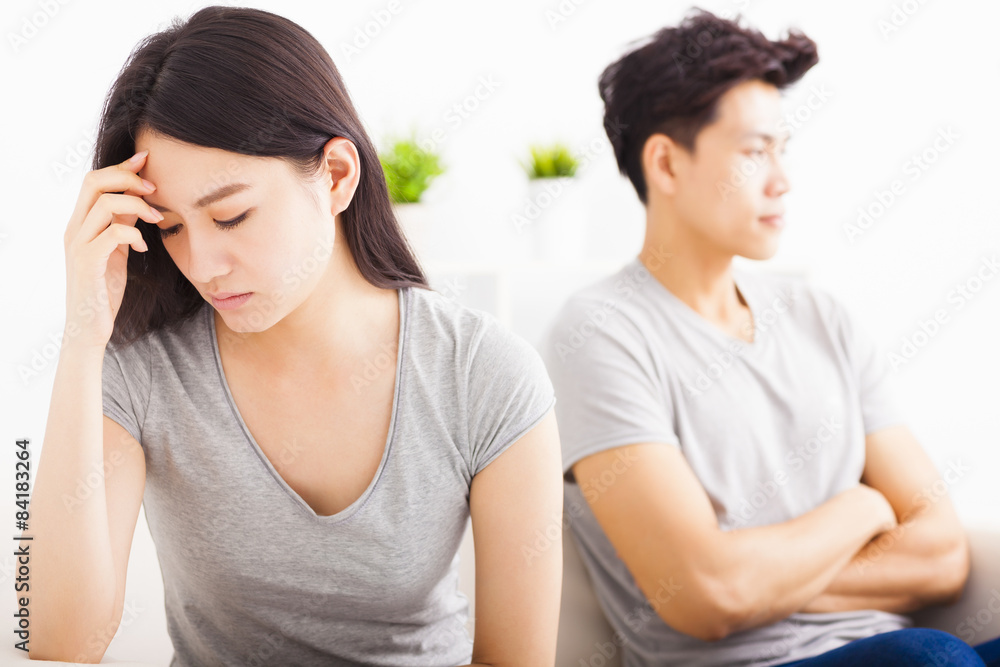 young Couple not talking after fight in living room young Couple not talking after fight in living room