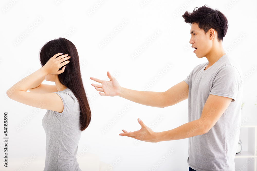 Angry young couple arguing in living room Angry young couple arguing in living room