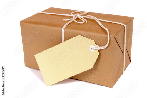 Brown paper wrapped package parcel box one single small with white string address or message label tag isolated on white background photo