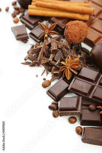 Dark chocolate bar with coffee beans and cinnamon on white backg