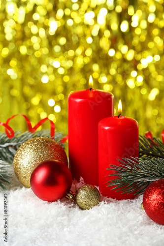 Branch of Christmas tree with balls and candles on snow