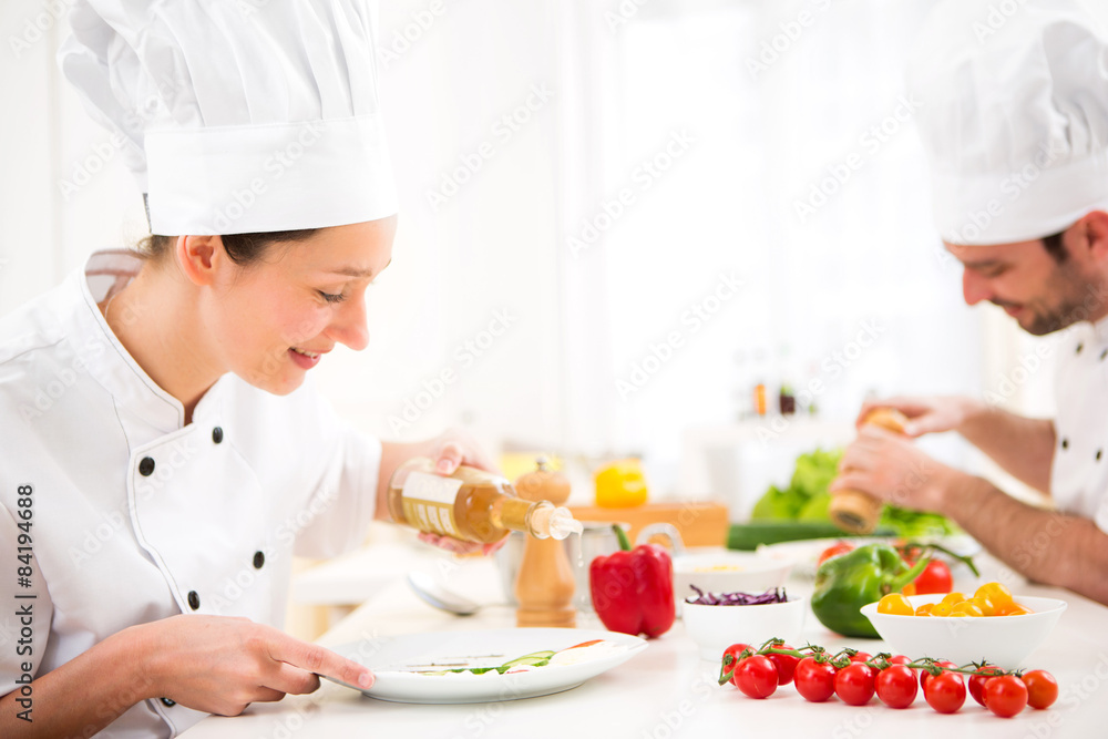 Young attractive professional chef cooking in his kitchen Young attractive professional chef cooking in his kitchen