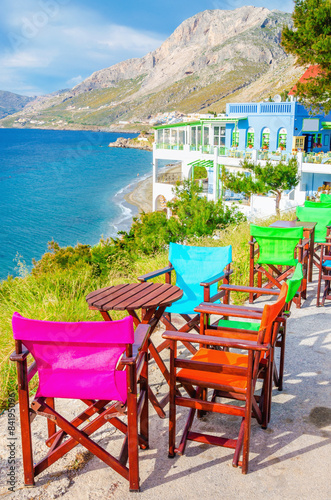 Colorful wooden chairs with view on sea, Greece