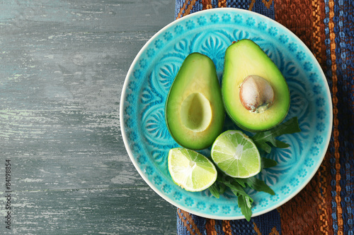Fotografie Sliced avocado and lemon lime on wooden background