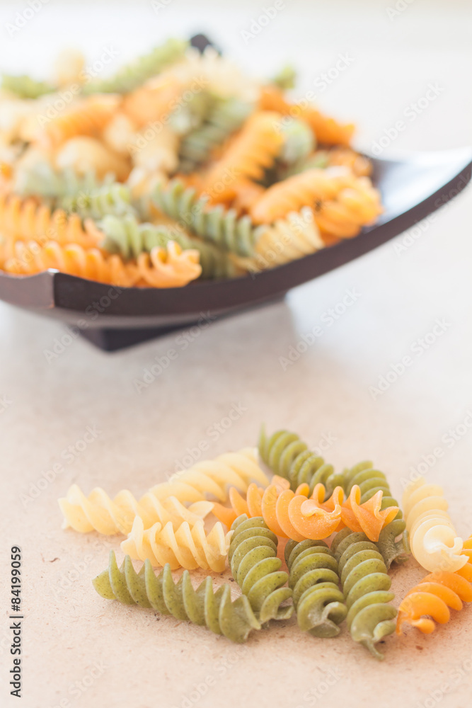 Raw fusilli pasta on wooden tray Raw fusilli pasta on wooden tray