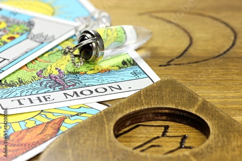 Tarotkarte THE MOON mit Pendel auf Ouija photo