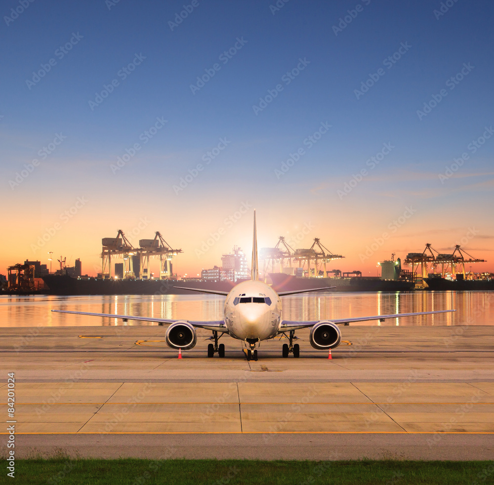 Obraz premium cargo plane parking in airport runways and shipping port behind