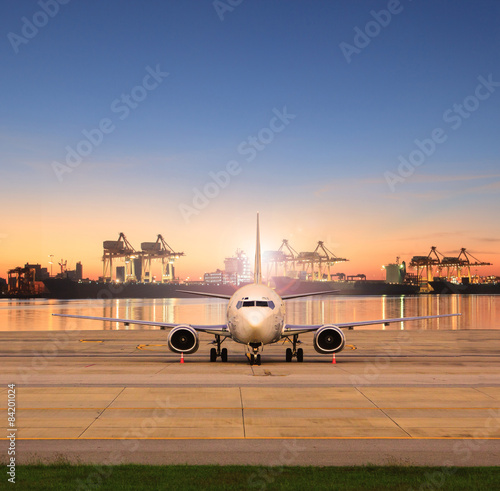 cargo plane parking in airport runways and shipping port behind