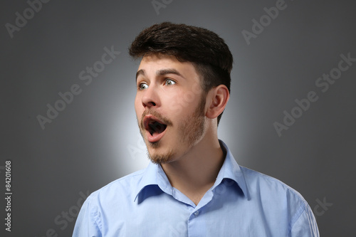 Portrait of surprised man on gray background