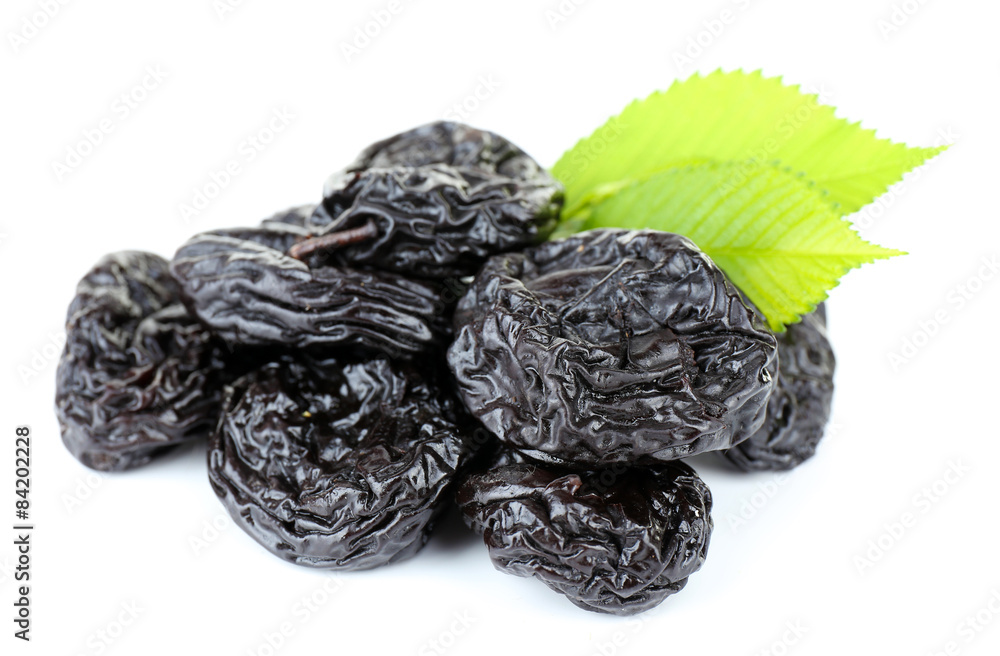 Pile of prunes with green leaves isolated on white Pile of prunes with green leaves isolated on white