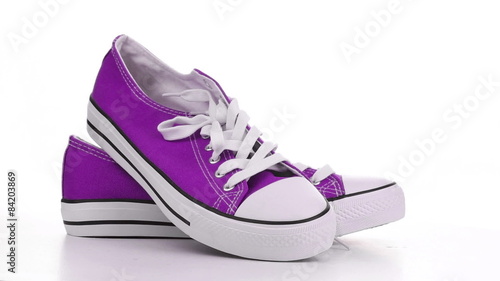 Purple sneakers revolve on a white background
