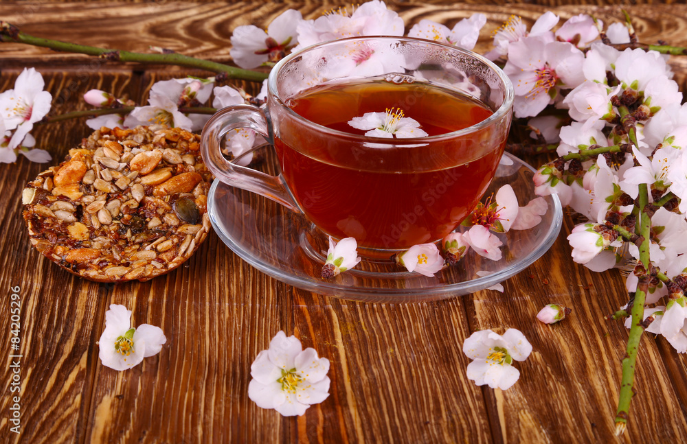 tea and a branch of cherry blossoms on a wooden tea and a branch of cherry blossoms on a wooden