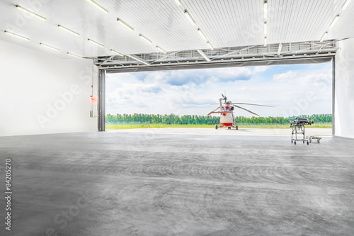 Helicopter standing in front of the hangar on a platform. photo