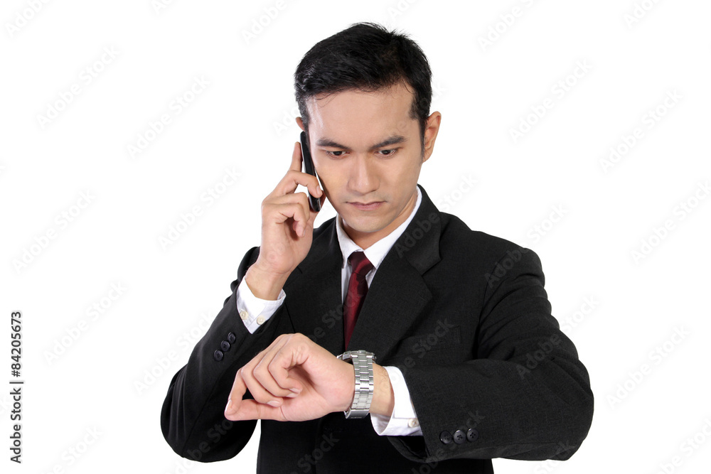 Businessman on phone checking the time, isolated on white Businessman on phone checking the time, isolated on white