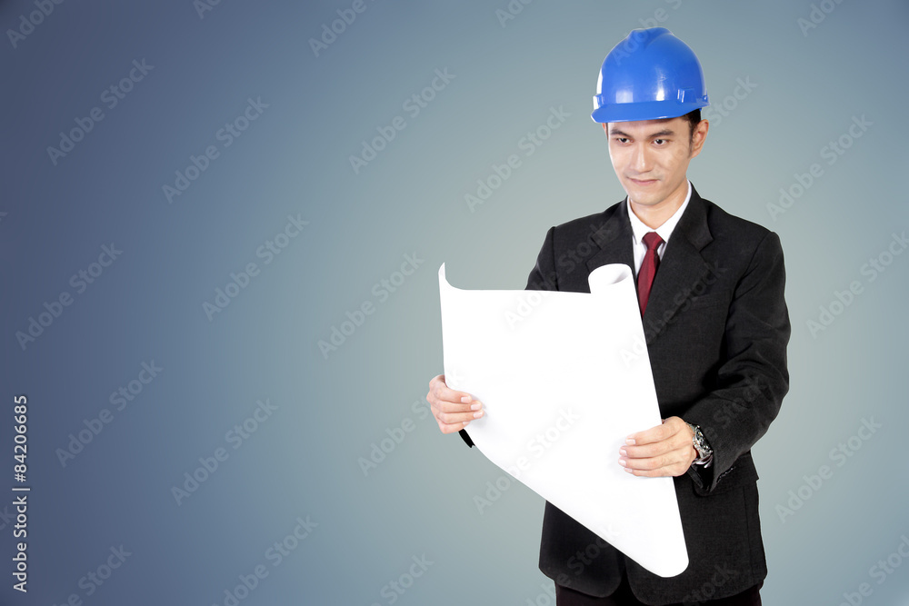 Young architect looking at paper scroll Young architect looking at paper scroll