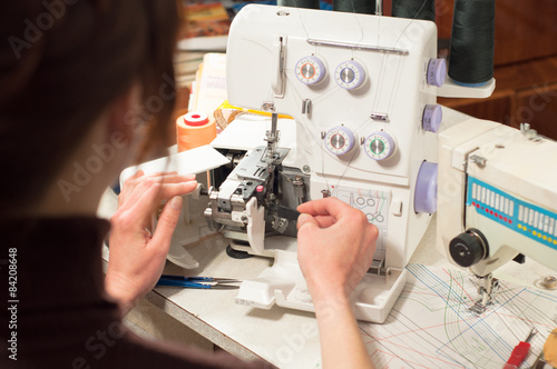 A woman cleans a serger brush the dirt