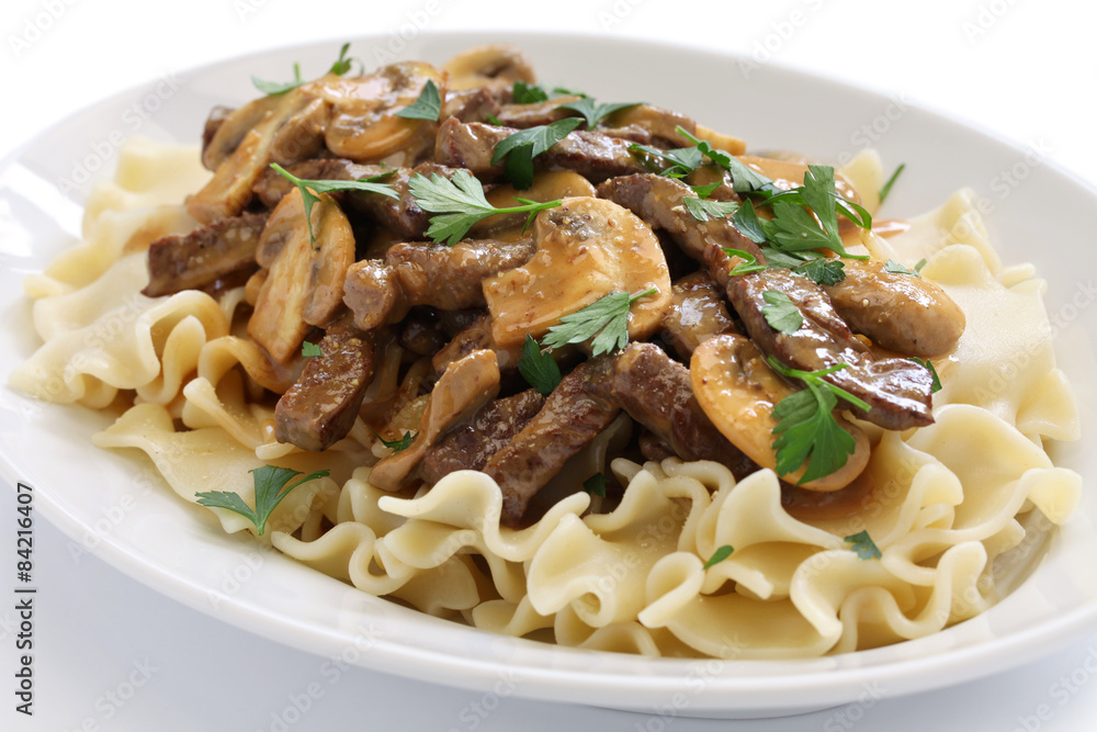 beef stroganoff with pasta, russian cuisine on white background beef stroganoff with pasta, russian cuisine on white background
