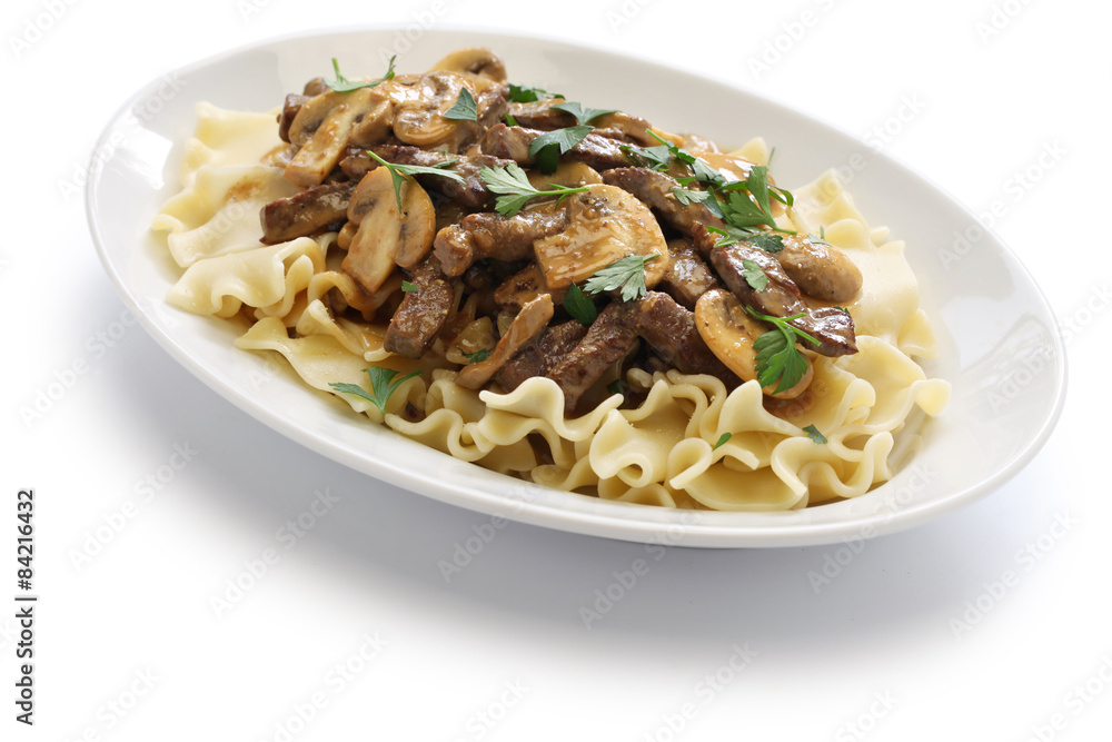 beef stroganoff with pasta, russian cuisine on white background