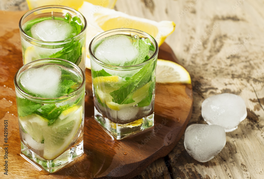 Glass of water with fresh lemon, ice and mint, selective focus Glass of water with fresh lemon, ice and mint, selective focus
