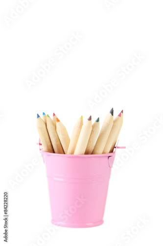 Pink bucket with pencils isolated on white