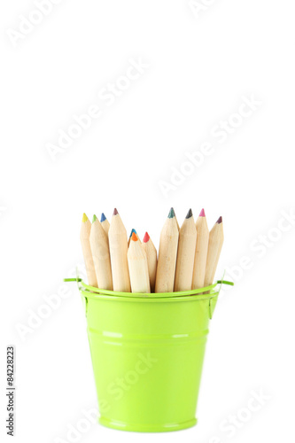 Green bucket with pencils isolated on white