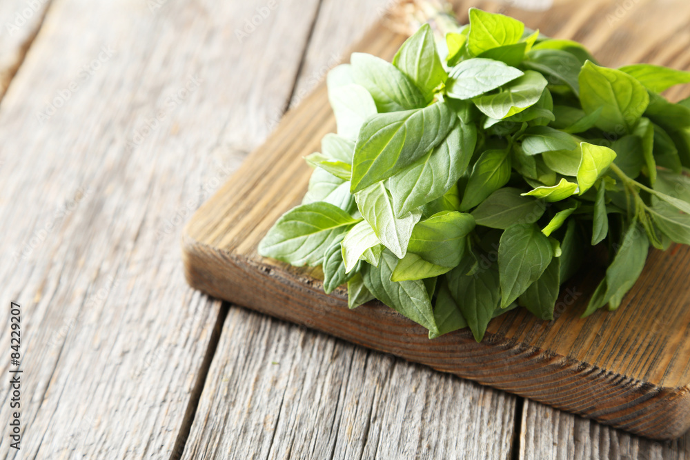 Basil leaves on cutting board grey wooden background Basil leaves on cutting board grey wooden background