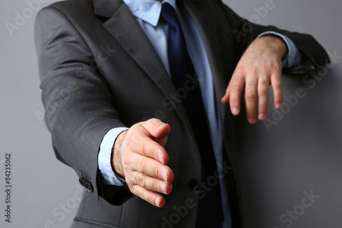Man wearing a suit offering to shake hands