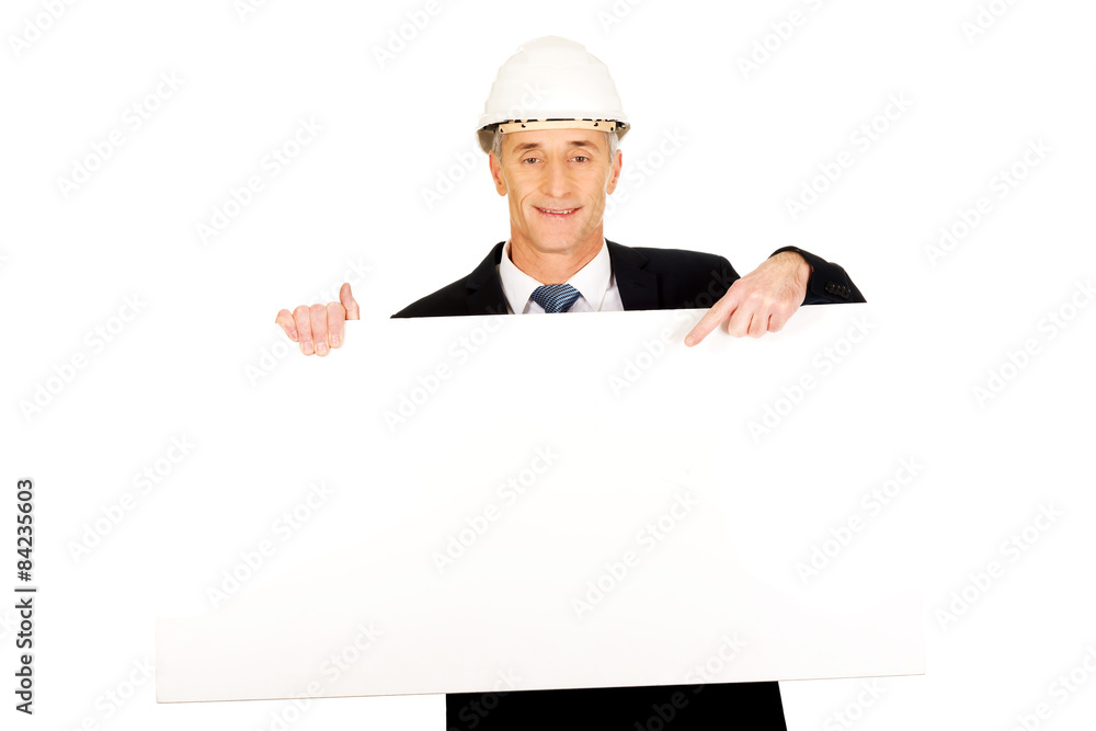 Businessman with hard hat holding empty banner Businessman with hard hat holding empty banner