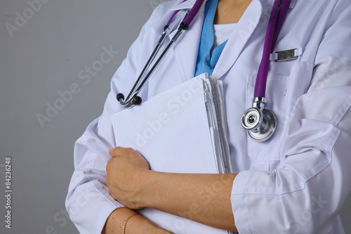 Female doctor standing with a folder , isolated on white
