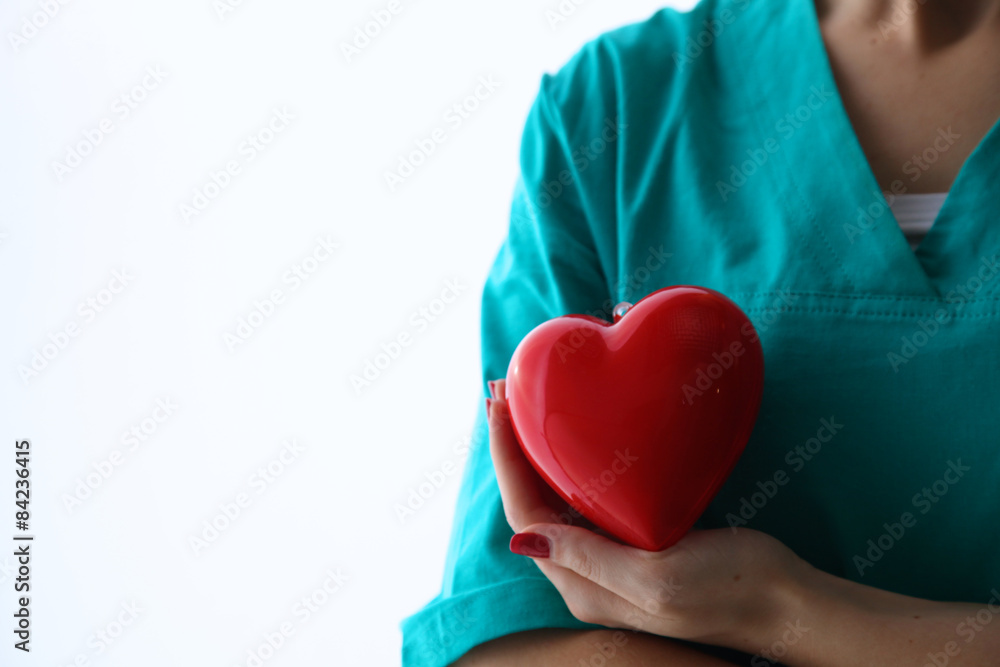 Female doctor with stethoscope holding heart over white Female doctor with stethoscope holding heart over white