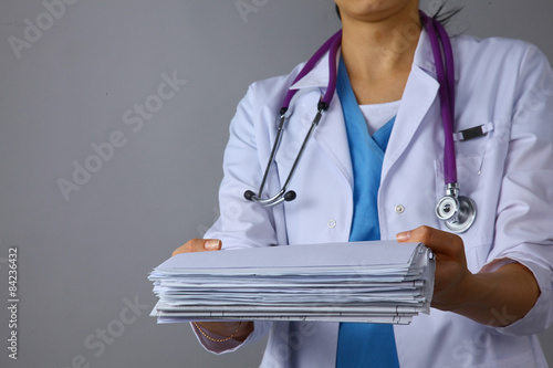 Young female doctor giving a stack of documents 